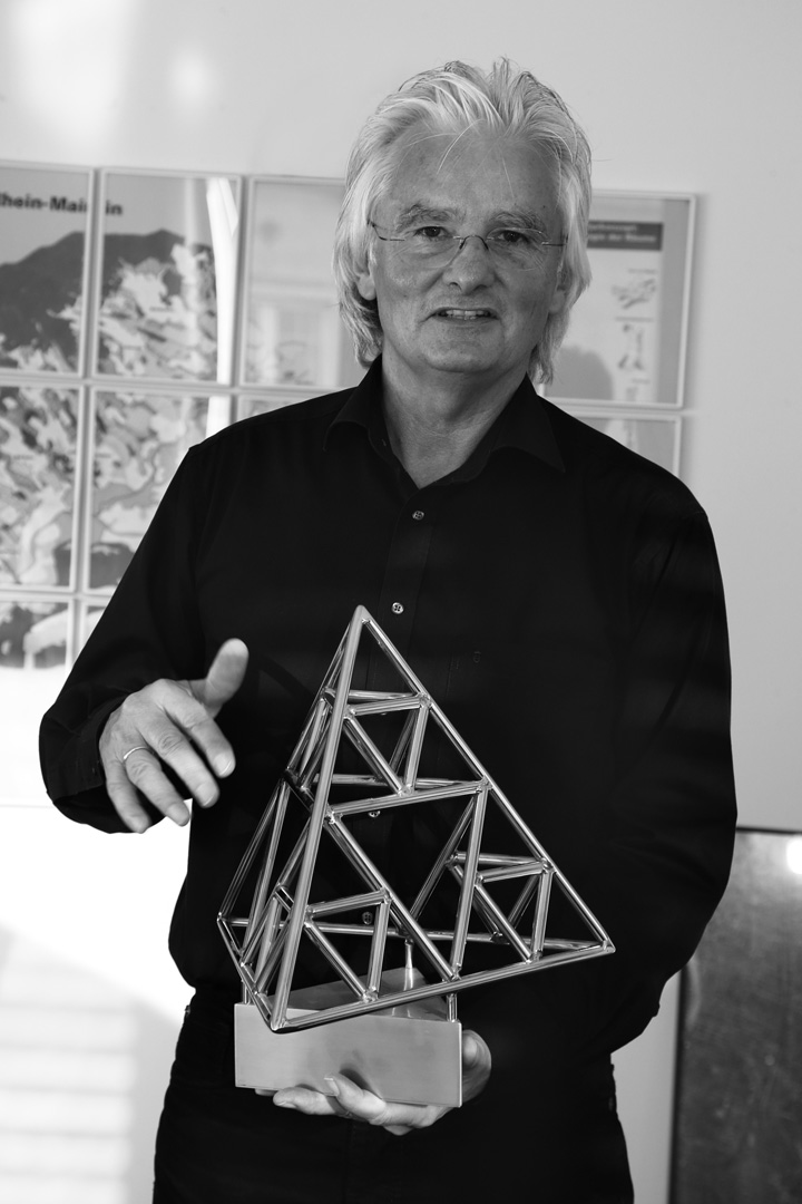 Prof. Wolfgang Christ mit einem Modell seines Tetraeders.